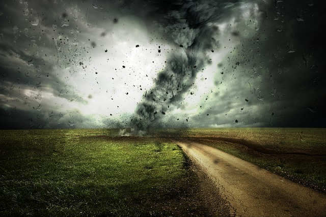 a hurricane running through an open field and causing dark sky