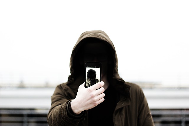 a man with a hood taking selfie