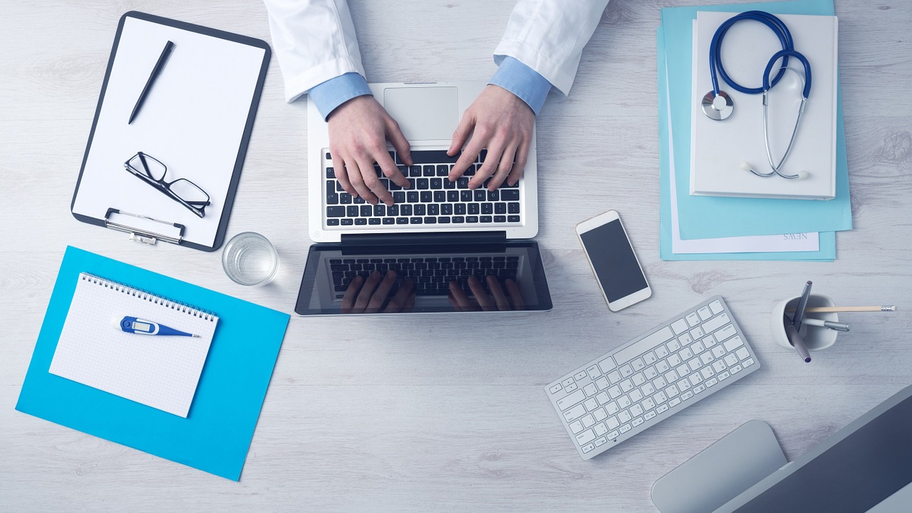 doctor typing on his laptop