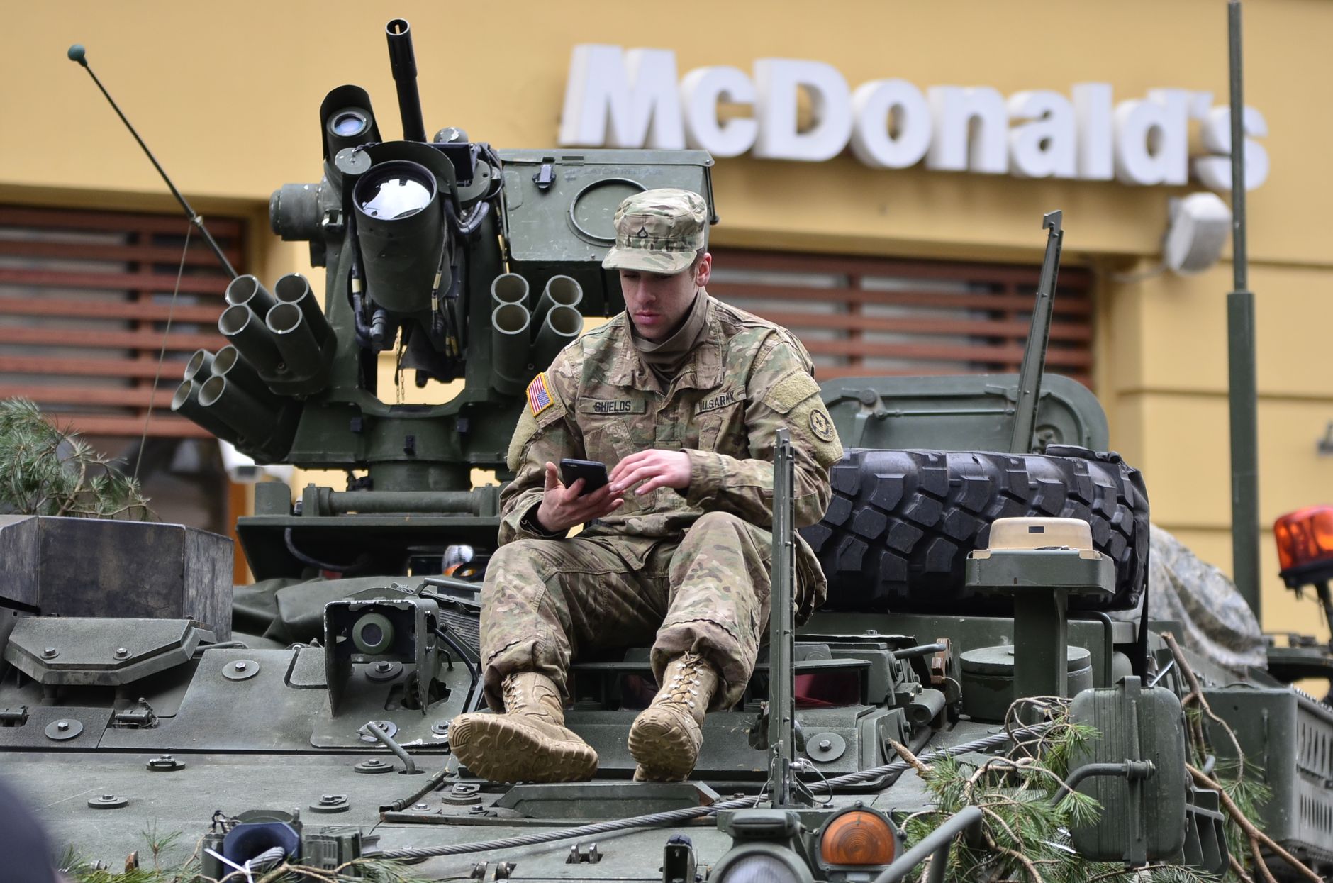 military man sitting in the tank in front of McDonald