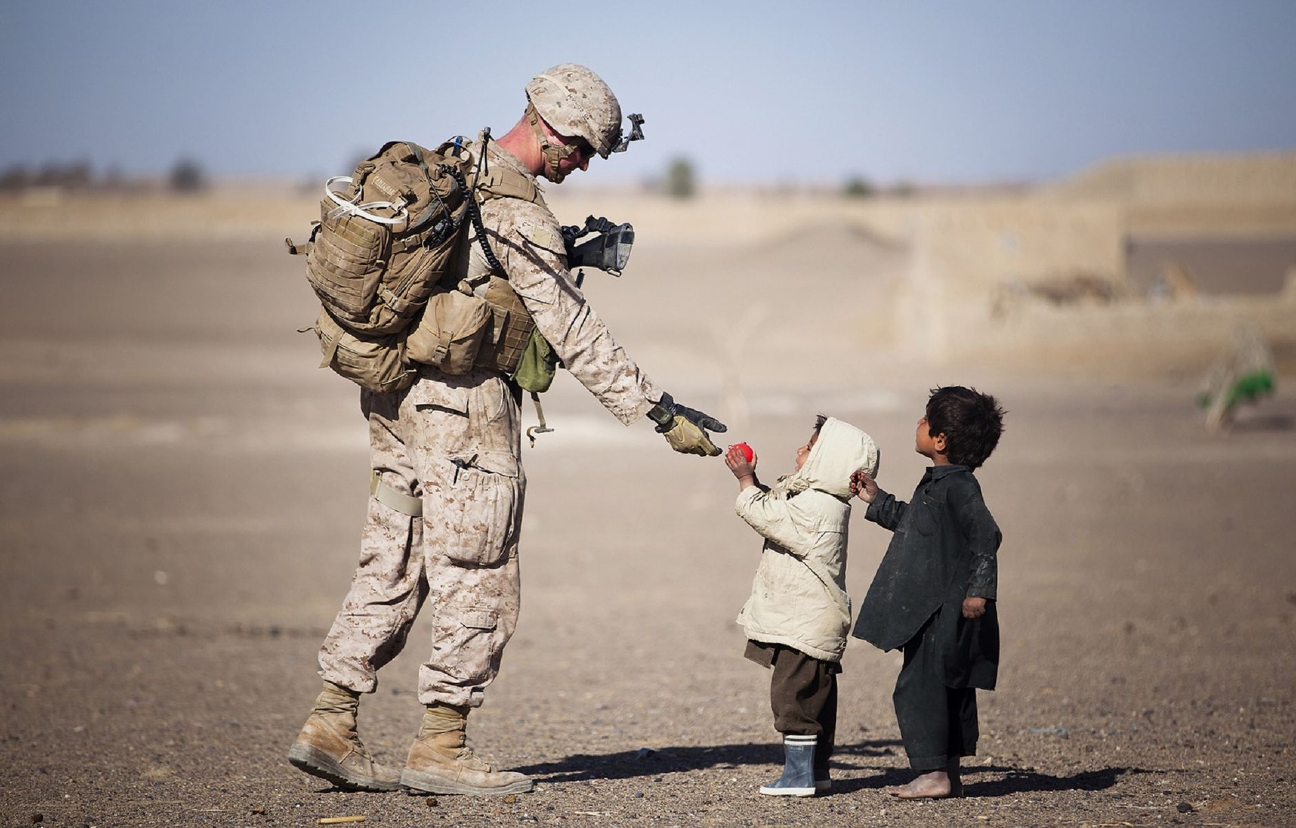 military man helping children