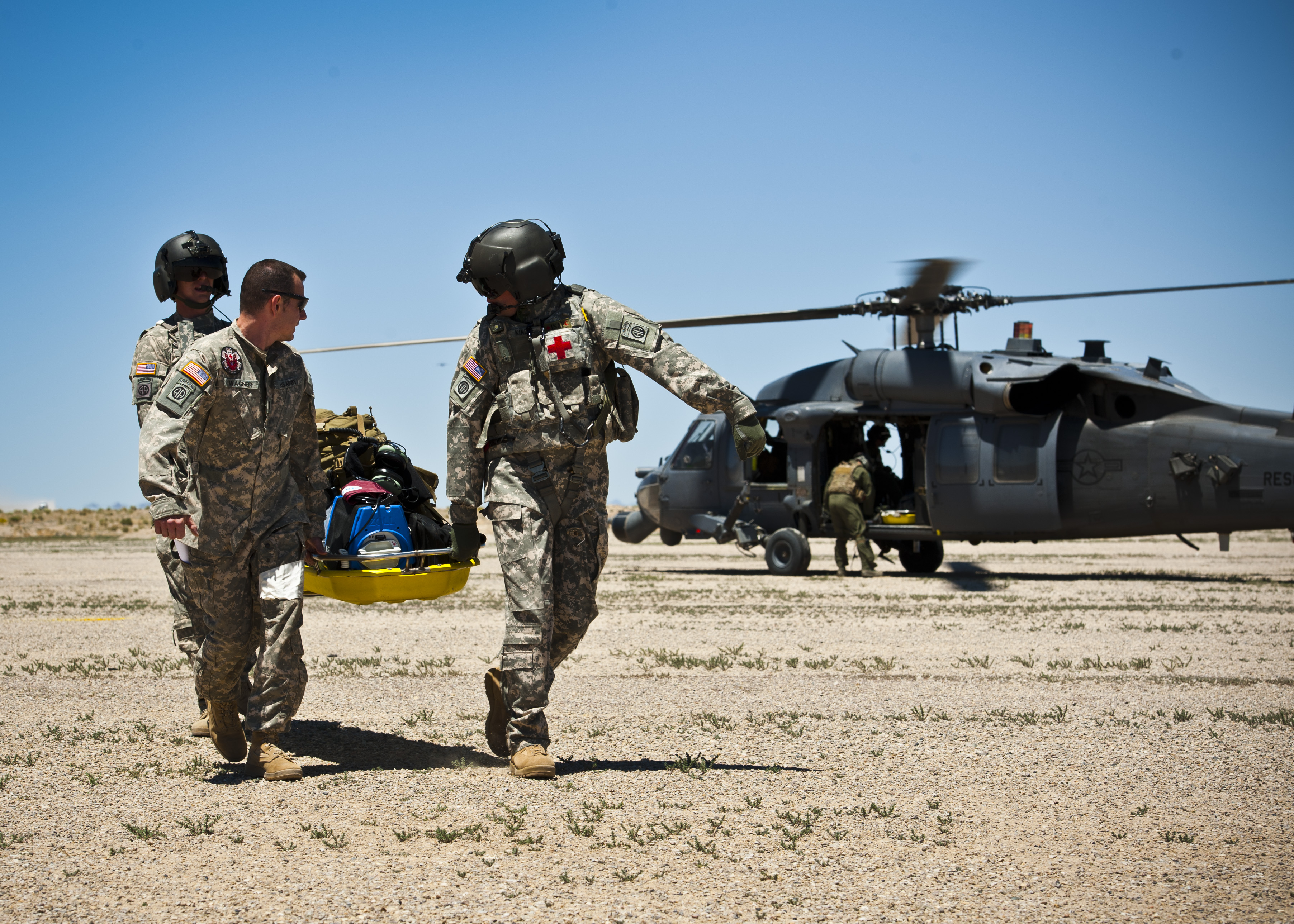 military men carrying a wounded soldier