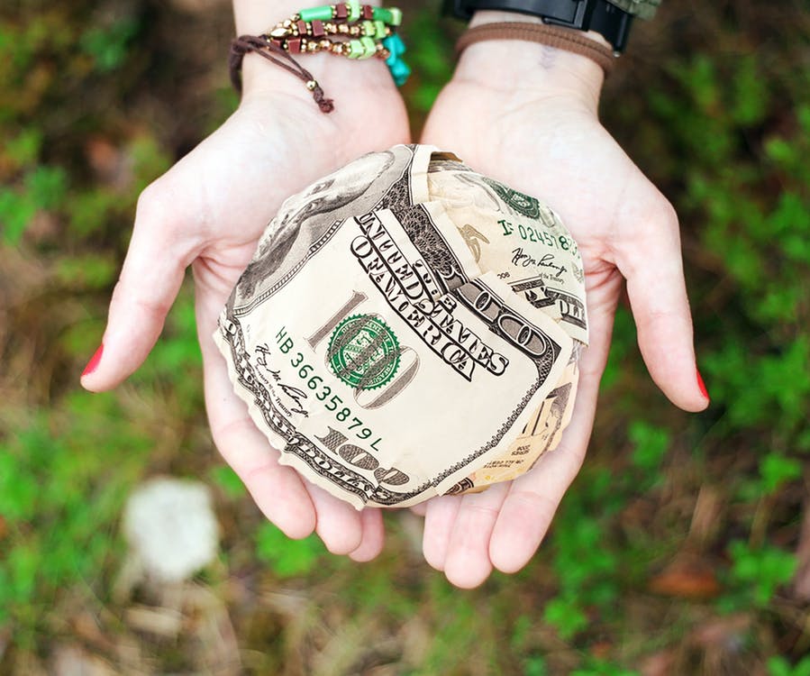 person holding money for donation